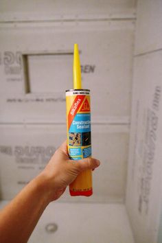 a person holding up a tube of glue