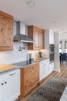 a kitchen with wooden cabinets and white walls