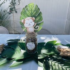 there is a monkey in a jar on the table with leaves and other things around it