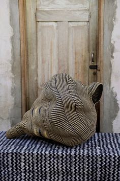 a hat sitting on top of a black and white checkered table cloth next to a wooden door