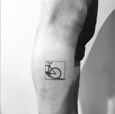 a black and white photo of a person with a bicycle tattoo on their arm,