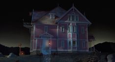 a pink house is lit up at night with the moon in the sky behind it