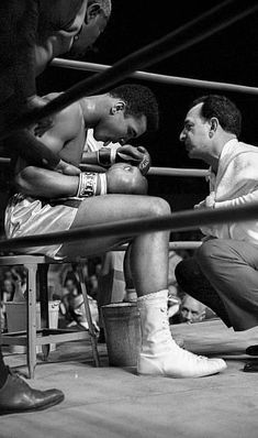 two men sitting next to each other in a boxing ring