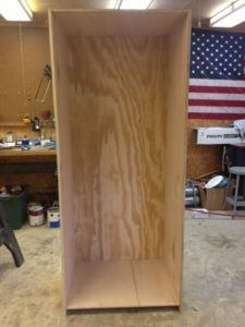 a wooden shelf in a room with an american flag on the wall