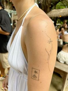 a woman with a small tattoo on her arm in front of a group of people