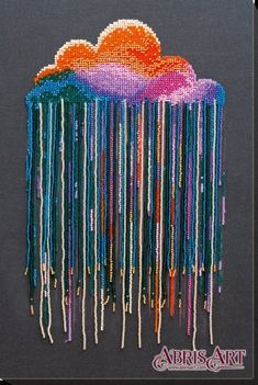 an art work with beads hanging from it's sides and clouds in the background