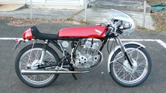 a red and black motorcycle parked in a parking lot