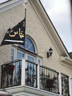 a black and gold flag on the balcony of a house