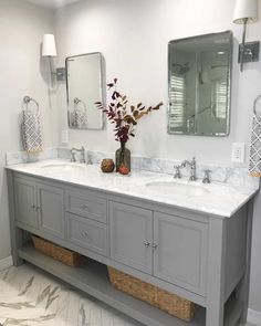 a bathroom with double sinks and two mirrors on the wall next to eachother