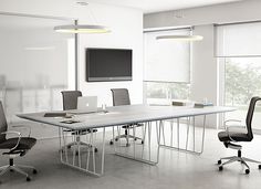 an empty conference room with chairs and a large table in front of a flat screen tv