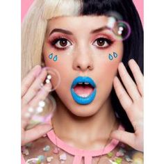 a woman with blue lipstick and bubbles on her face is blowing bubbles in front of her face