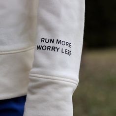 a close up of a person's arm with the words run more worry less printed on it