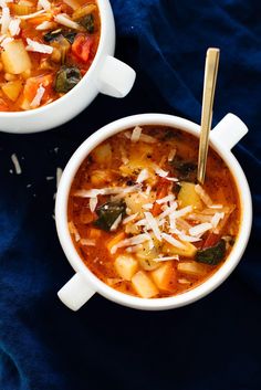 two bowls of vegetable soup on a blue cloth