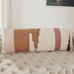 a large pillow sitting on top of a couch in a living room next to a window