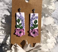 Turn heads with these elegant and timeless polymer clay dangle earrings. Each flower is meticulously handmade ensuring these are one of a kind. These earrings add a splash of elegance and femininity to any outfit. These perfectly enhance the beauty of any bride on her special day. Matching pairs of these on bridesmaids make for a classy sight. You can wear these on a date night with your husband or even in the office. These are versatile making them great for every occasion!  Don't miss out on t Dangle Flower Earrings In Polymer Clay, Dangle Flower Earrings In Polymer Clay For Gifts, Polymer Clay Earrings With 3d Flowers For Gift, Gift Earrings With 3d Flowers In Polymer Clay, Adjustable Polymer Clay Earrings With 3d Flowers, Elegant Earrings With 3d Flowers In Polymer Clay, Elegant Purple Polymer Clay Earrings, Purple Polymer Clay Earrings, Matching Pairs