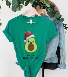 Grab a unique look this Christmas with this funny avocado themed xmas tshirt saying Avo Very Merry Christmas. This tee is ideal as a gift for avocado lovers (we all know one!) or for those who just want to bring a bit of humour to the festive season. We use the Bella Canvas 3001 tshirt which has quickly built a reputation as a higher quality product than its competitors.  Soft cotton and quality print make users fall in love with it over and over again. These t-shirts have-ribbed knit collars to Avocado Shirt, Christmas Tees, Very Merry Christmas, Prism Color, Look Plus, Semi Formal, Leisure Wear, Festival Season, Ribbed Knit