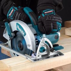 a man using a circular saw to cut wooden planks with a cordless tool