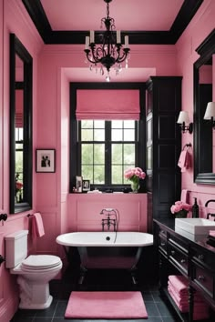 a pink bathroom with black and white fixtures, chandelier, toilet, sink and bathtub