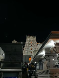 the temple is lit up at night with people walking down the stairs and onlookers