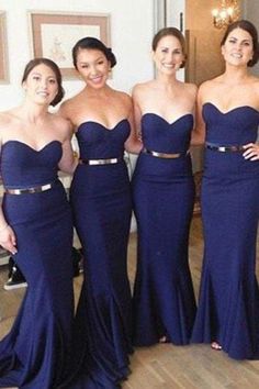 four beautiful women in long dresses posing for a photo together with their hands on their hipss