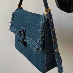 a denim purse hanging from a hook on a wall