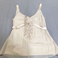 Beautiful Cream Top. Ties At Back. Satin Details. New Without Tags Cream Silk Party Tops, Sleeveless Cream Silk Top, Chic Formal Camisole Top, Cream Sleeveless Evening Top, Beige Camisole Top For Party, Beige Silk Top For Parties, Silk Beige Top For Party, Beige Silk Tops For Party, Beige Silk Party Tops