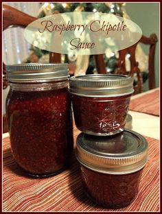 raspberry chipotte sauce in jars on a table with christmas tree in the background