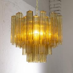 a yellow chandelier hanging from a ceiling in a room with white walls and windows