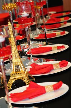 the table is set up with red napkins and place settings for an elegant dinner