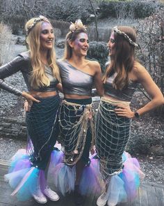 three women dressed in mermaid costumes posing for the camera