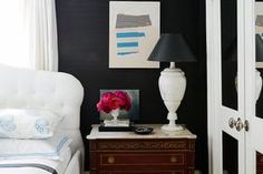 a white chair sitting next to a lamp on top of a table in a room