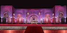 the stage is set up for an event with purple lighting and red carpeted flooring