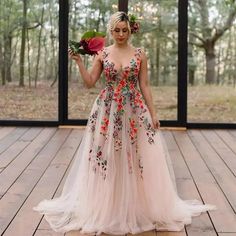 a woman is standing on a wooden floor with flowers in her hair and wearing a dress