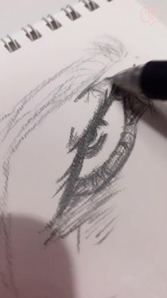 a person is drawing on paper with a pen