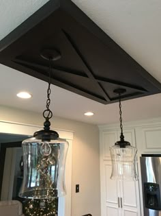 two lights hanging from the ceiling in a kitchen