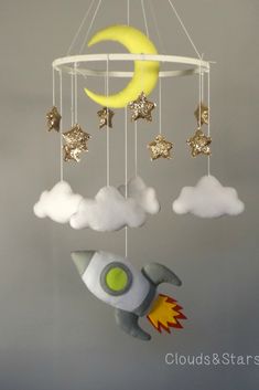 a mobile with stars, moon and rocket ship hanging from it's sides in the sky