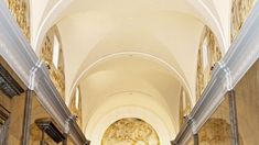 the inside of a church with pews and statues on either side of the aisle