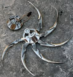 a pair of silver scissors sitting on top of a stone floor next to a rope