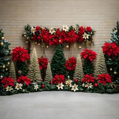 christmas decorations and poinsettis are on display in front of a brick wall