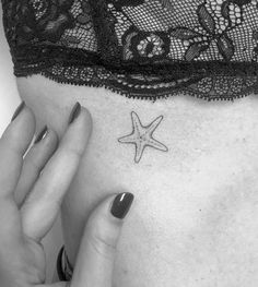 a woman's stomach with a small starfish tattoo on her left side ribcage