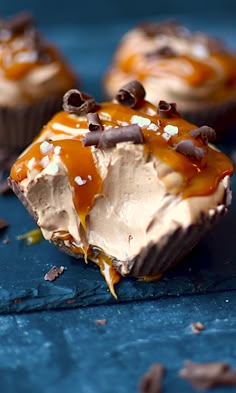 chocolate cupcakes with caramel frosting and oreo chips on blue surface