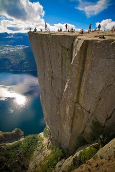 two pictures of people standing on top of a cliff next to the ocean and mountains