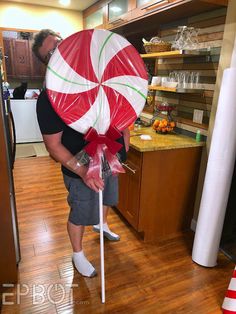 a man holding a giant candy cane in his hands