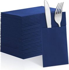 a stack of blue napkins with a knife and fork sticking out of it's pocket