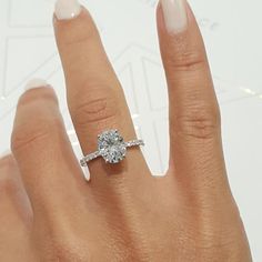 a woman's hand with a diamond ring on top of her finger and an engagement band