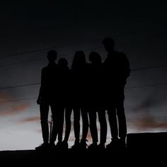 a group of people standing next to each other in front of power lines at night