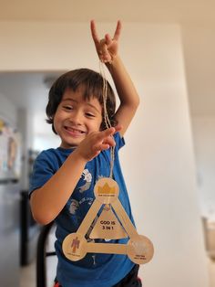 a young boy holding up a wooden sign