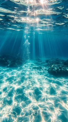 the sun shines through the water as it reflects on the ocean floor, with sunlight shining