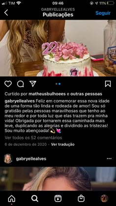 a woman sitting at a table in front of a cake with pink flowers on it