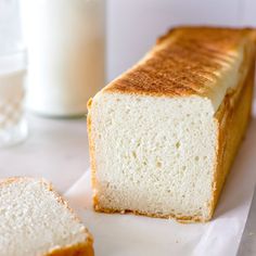 a loaf of white bread next to a glass of milk